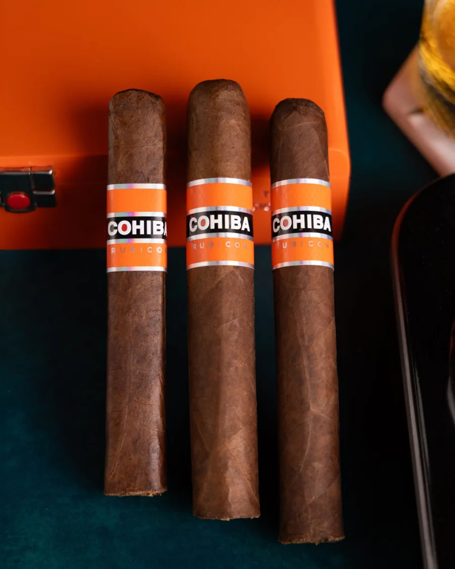 Three Cohiba Rubicon cigars beside an orange box