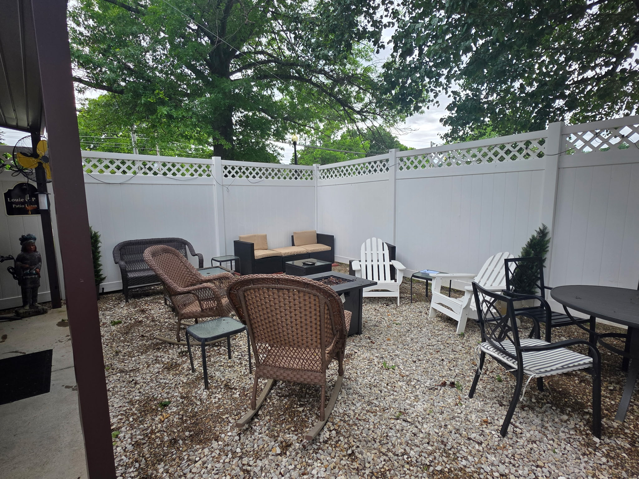 The outdoor patio at The Office Cigar Lounge — wicker chairs, a fire pit, and a privacy fence